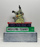 (Jonathan Edelhuber) "Still Life With Pokemon Sculpture on Art Books"